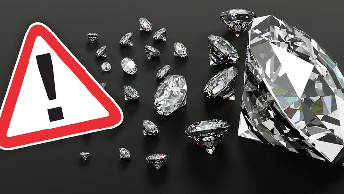 Tipps zum Erkennen einer Diamant Fälschung: Stein auf eine Zeitung oder ein Buch legen, Stein unter ultraviolettes Licht halten, Diamant anhauchen, in ein Glas Wasser werfen, Stein erwärmen